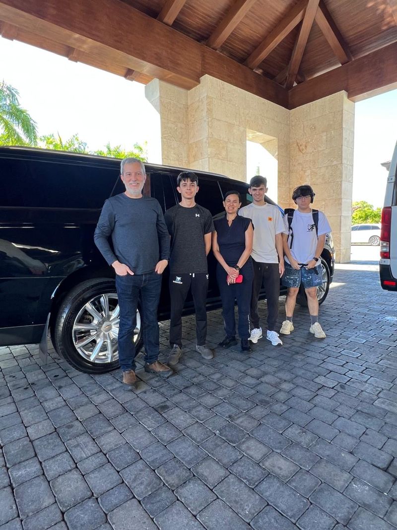 Family of five beside a Layla SUV at a resort entrance